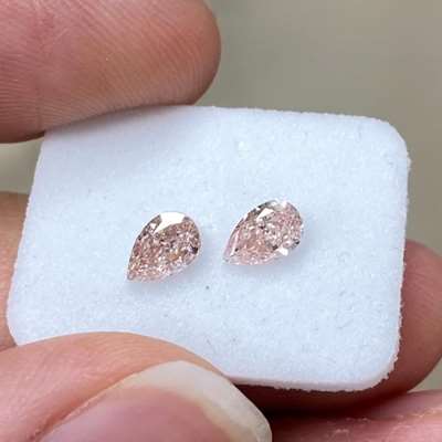 matching pair of GIA-certified natural fancy brownish pink diamonds. These stunning pear-shaped gems weigh 0.36 carats and 0.41 carats respectively, with clarity ratings of SI2 and VS2